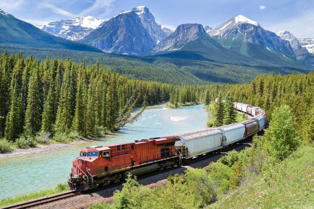 A train winding through snowy mountain passes in the Canadian Rockies.